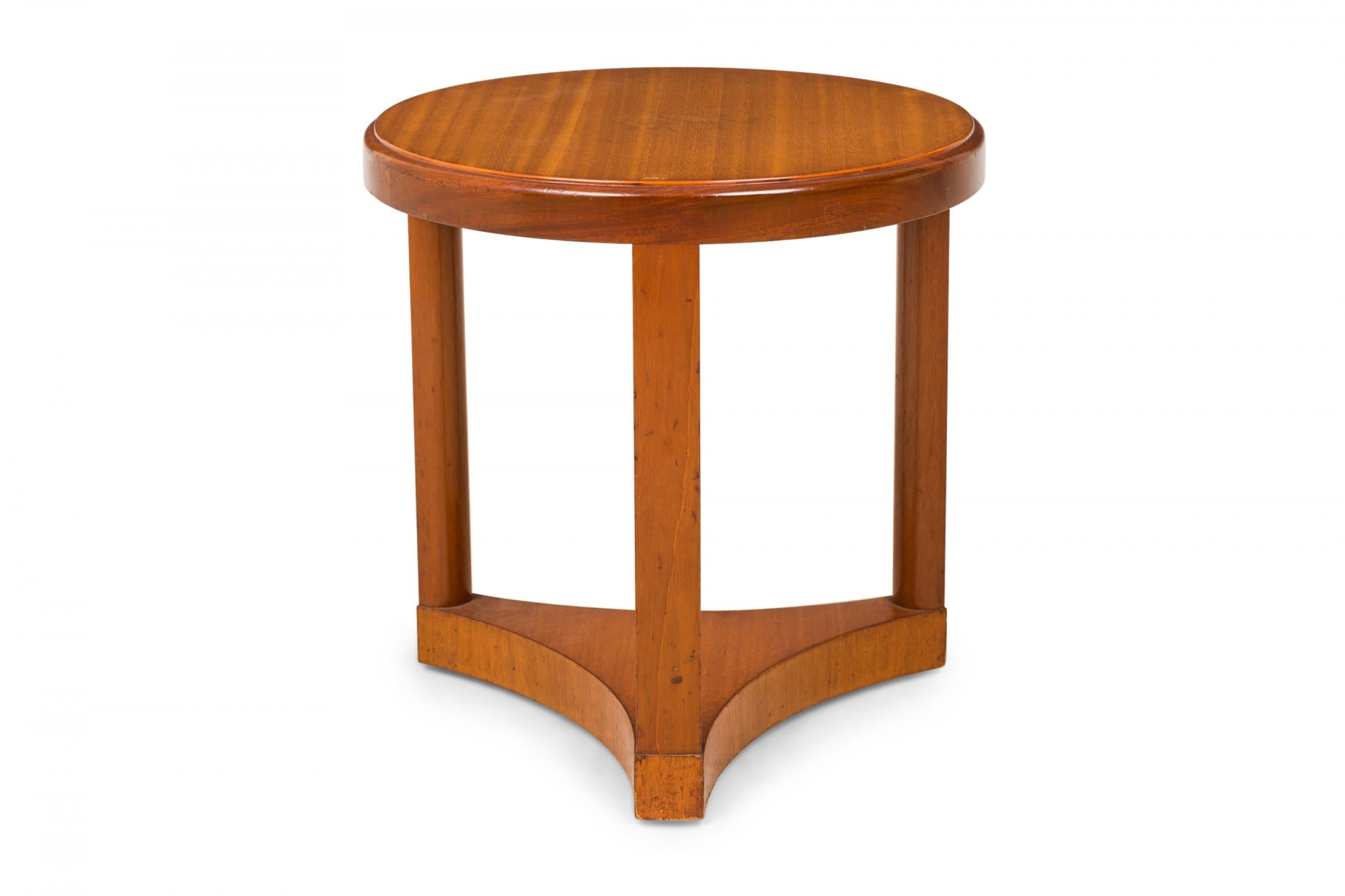 American Mid-Century round wooden side / end table with a circular top with beveled edge resting on three vertical rectangular supports connected to a triangular scooped side base. (EDWARD WORMLEY)(Similar shorter table: DUF0637).