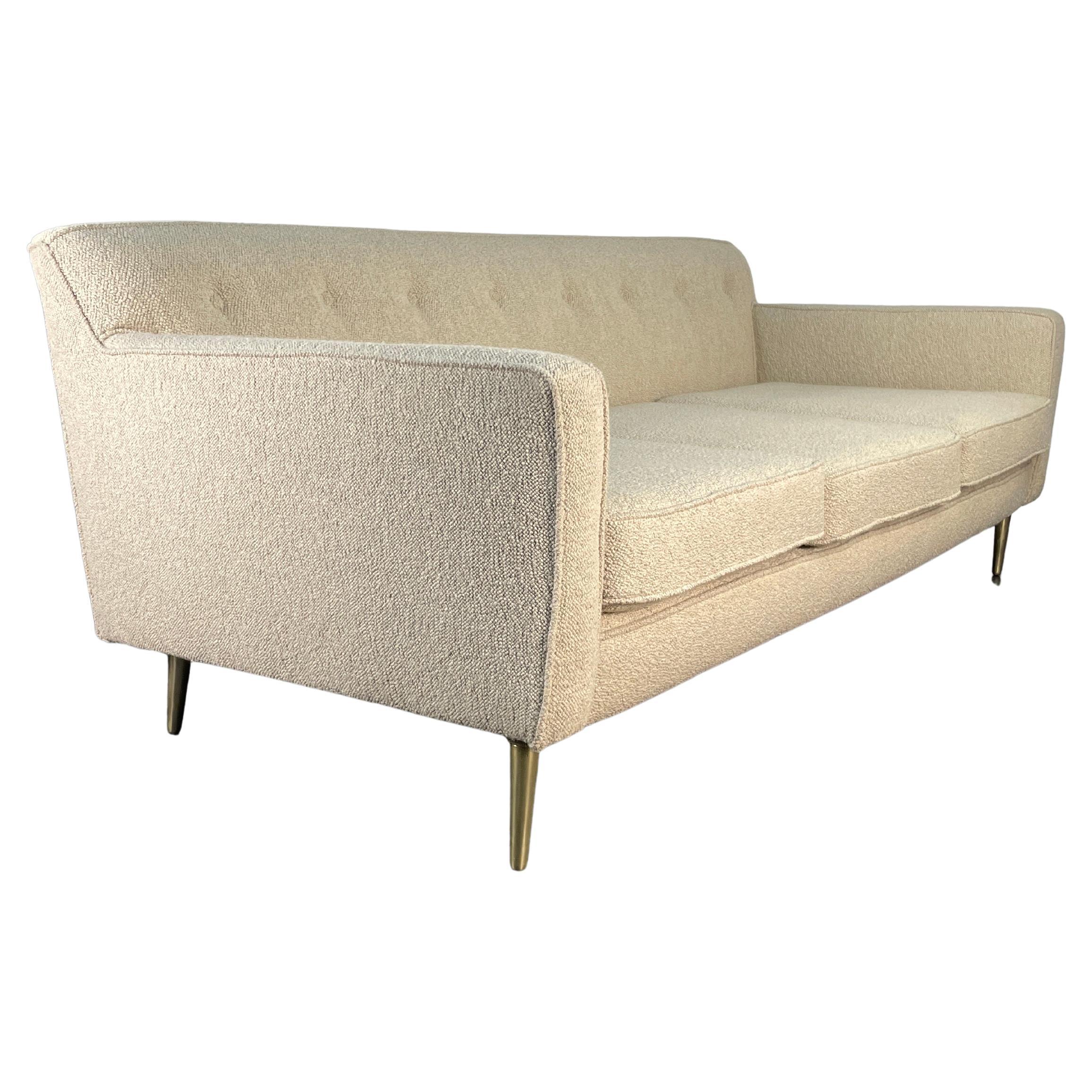 Sophisticated 3 seater sofa designed by Edward Wormley with Brass legs for Dunbar. We have newly upholstered it in Maharam Hearth / Amphitheater boucle made in Belgium. Beautiful structured clean lines and brass legs makes this sofa a classic and