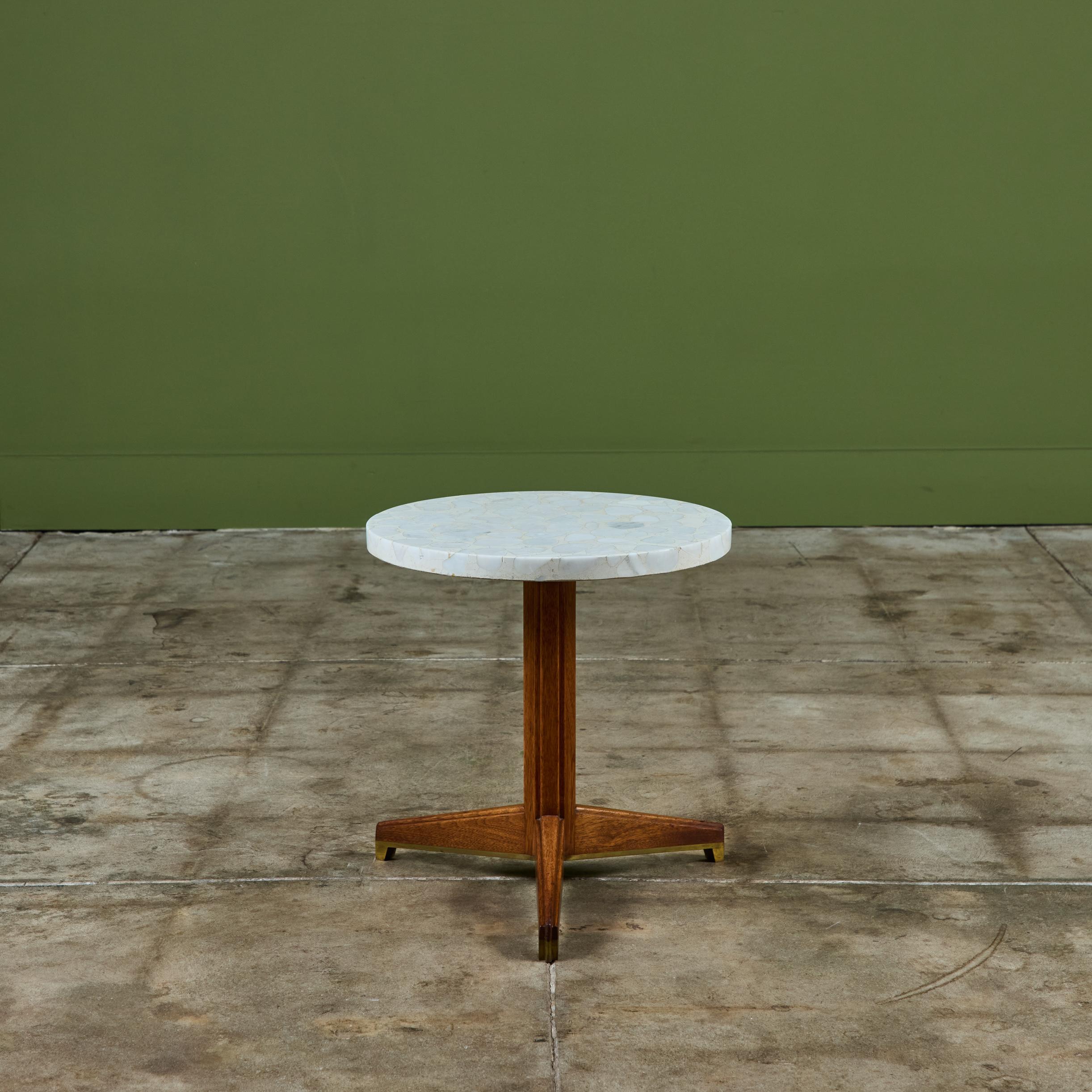 Round Terrazzo top side table by Edward Wormley for Dunbar, c.1950s, USA. This table features a terrazzo stone top and mahogany, fluted tripod base.  Retains original Dunbar metal label on the underside.

Dimensions
15