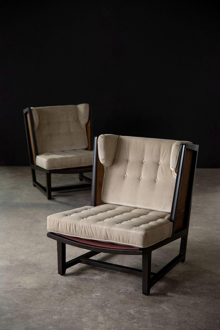 A rare pair of Dunbar Wing lounge chairs in sculpted mahogany and woven cane designed by Edward Wormley. Reupholstered in a neutral Perennials velvet complete with new foam and refinished to the highest possible standard in an espresso stain with a