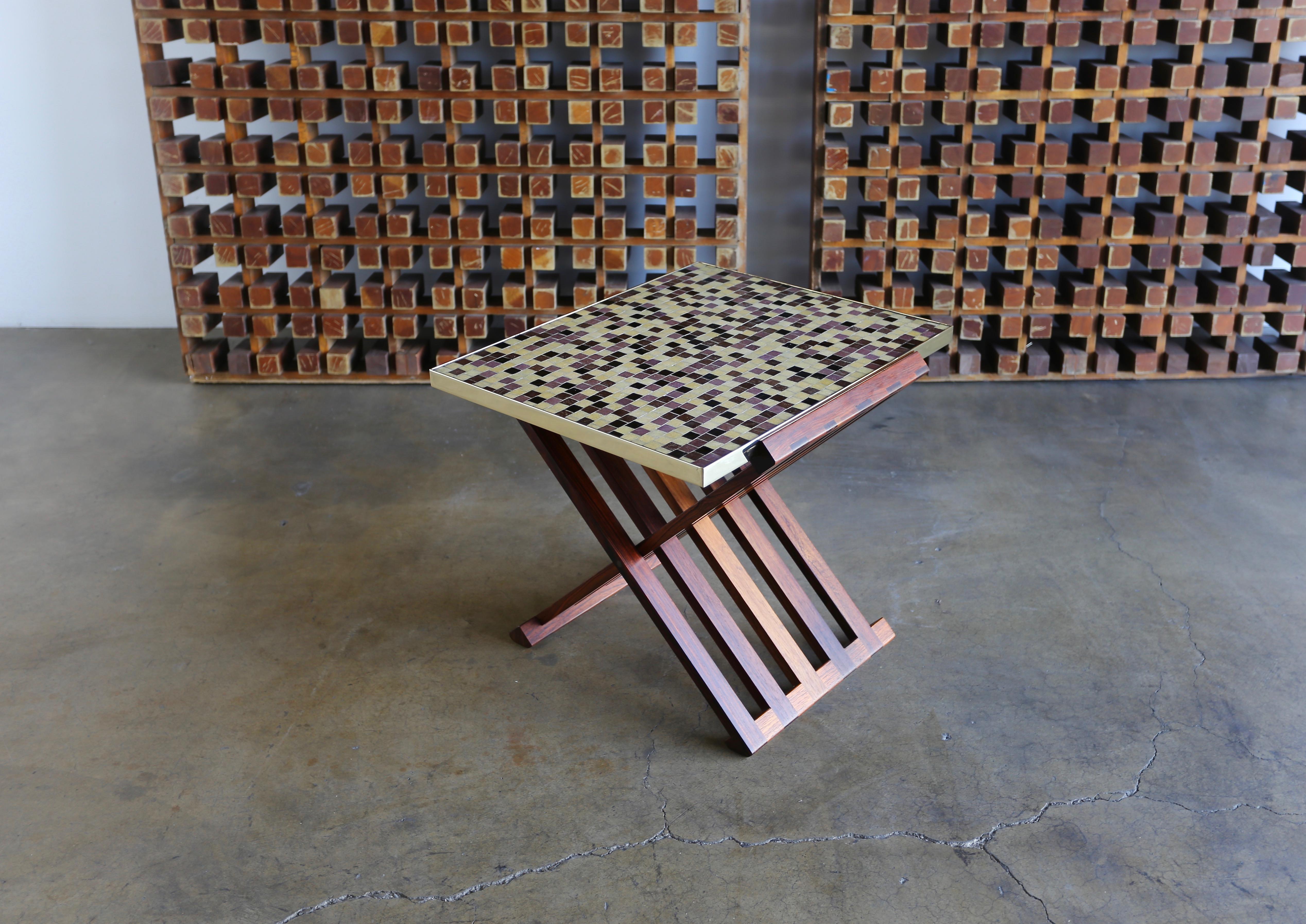 Edward Wormley X-base rosewood and Murano tile-top table. Manufactured by Dunbar, circa 1955. Highly figured grain to the solid rosewood base. Solid brass frames to the Murano glass tile top.