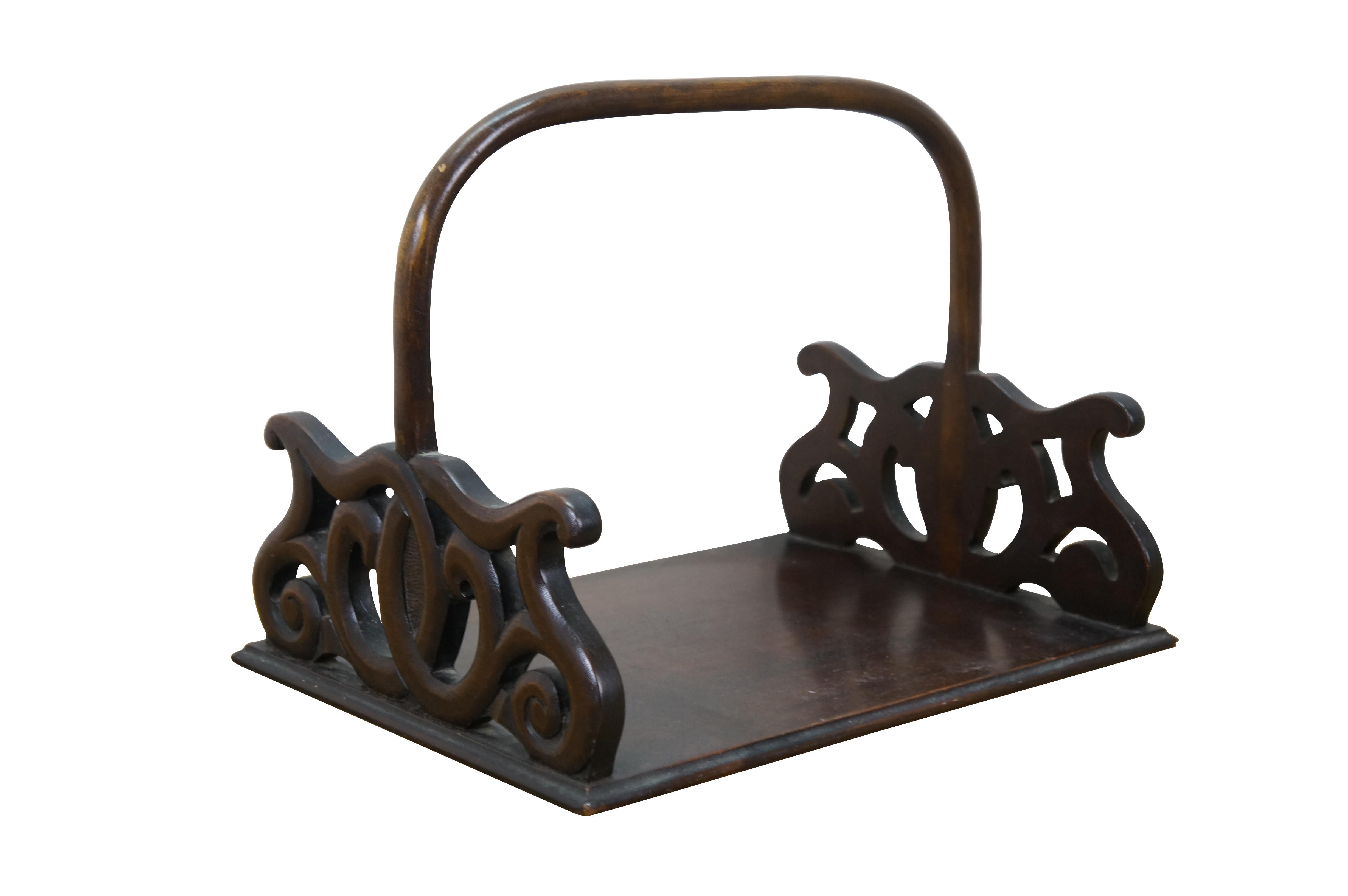 Porte-livres / plateau de bibliothèque / porte-revues en acajou du 20e siècle. Base rectangulaire avec extrémités en volutes percées, reliée à une poignée fixe en bois courbé.

Dimensions :

14.5