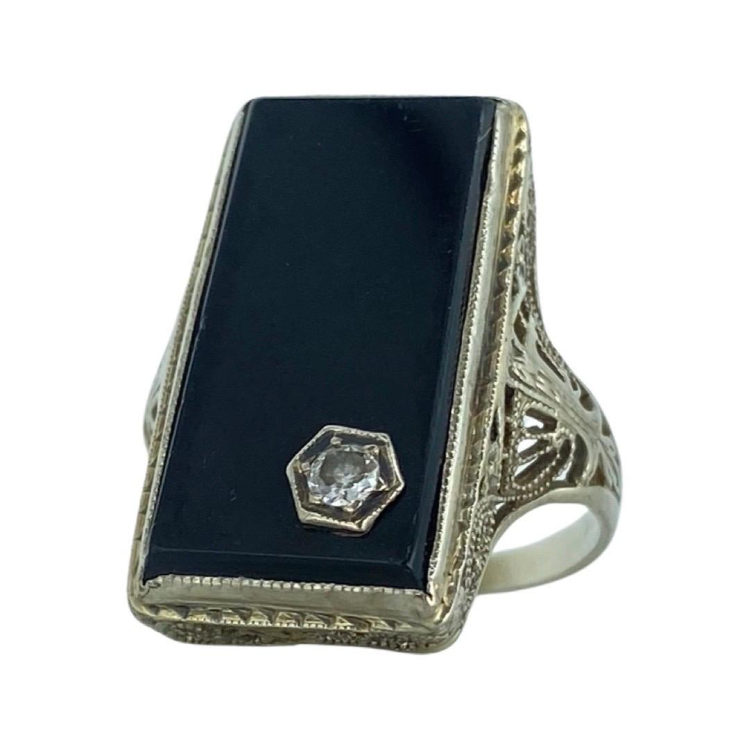 Edwardian 0.07 Carat Diamond In Rectangular Onyx Filigree Ring 14k White Gold. The diamond is a rose cut which dates back to Edwardian era and weights approx 0.07 carat. The diamond is set inside the onyx stone. The onyx stone measures 20mm and the