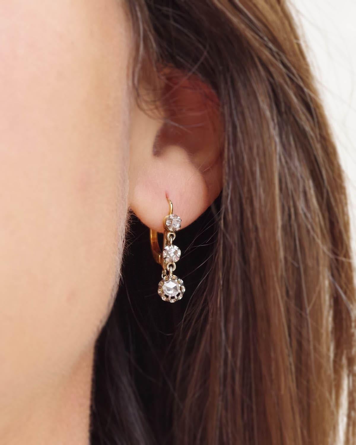 Boucles d'oreilles édouardiennes en or 18 carats et platine avec un diamant de 0,36 ct. Boucles d'oreilles dormeuses composées de trois étages sertis de diamants, le diamant principal, en taille rose hollandaise, pèse environ 0,18 ct. Boucles