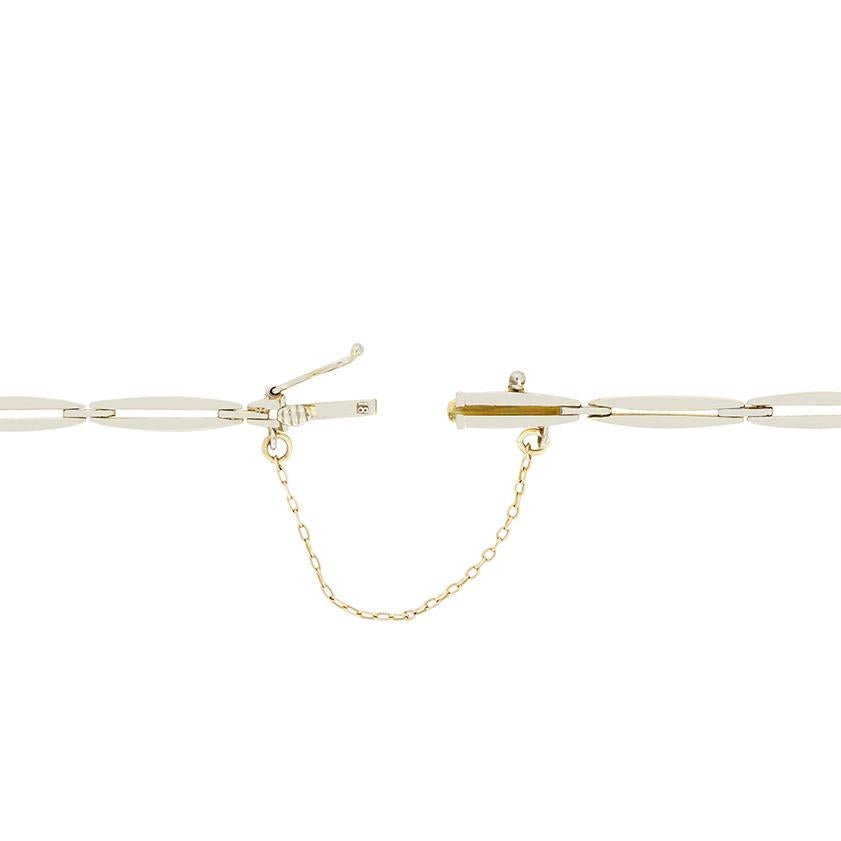 Este elegante brazalete eduardiano gira en torno a una línea de diamantes de talla antigua, enmarcados por delicados detalles de talla rosa. Los diamantes tienen un total de 0,40 quilates y su calidad varía de G a H en color y de VS a SI en