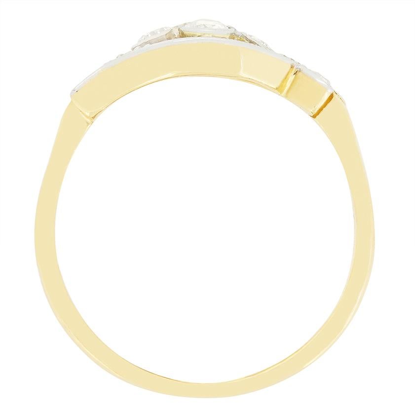 This unique twisting cluster ring dates to the Edwardian era. Four sparkling old cut diamonds take centre stage, rub over set and totalling 0.40 carat. Each diamond is of matching quality at G in colour and VS in clarity. Shoulders of platinum