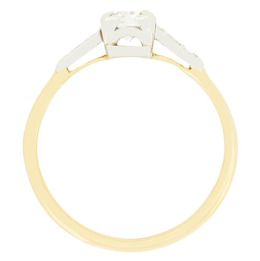 Questo meraviglioso anello solitario edoardiano presenta al centro un diamante taglio vecchio da 0,40 carati. Il diamante scintillante ha un colore G e una purezza SI1 ed è incastonato in una pinza di platino a forma di scatola. Su ogni spalla sono