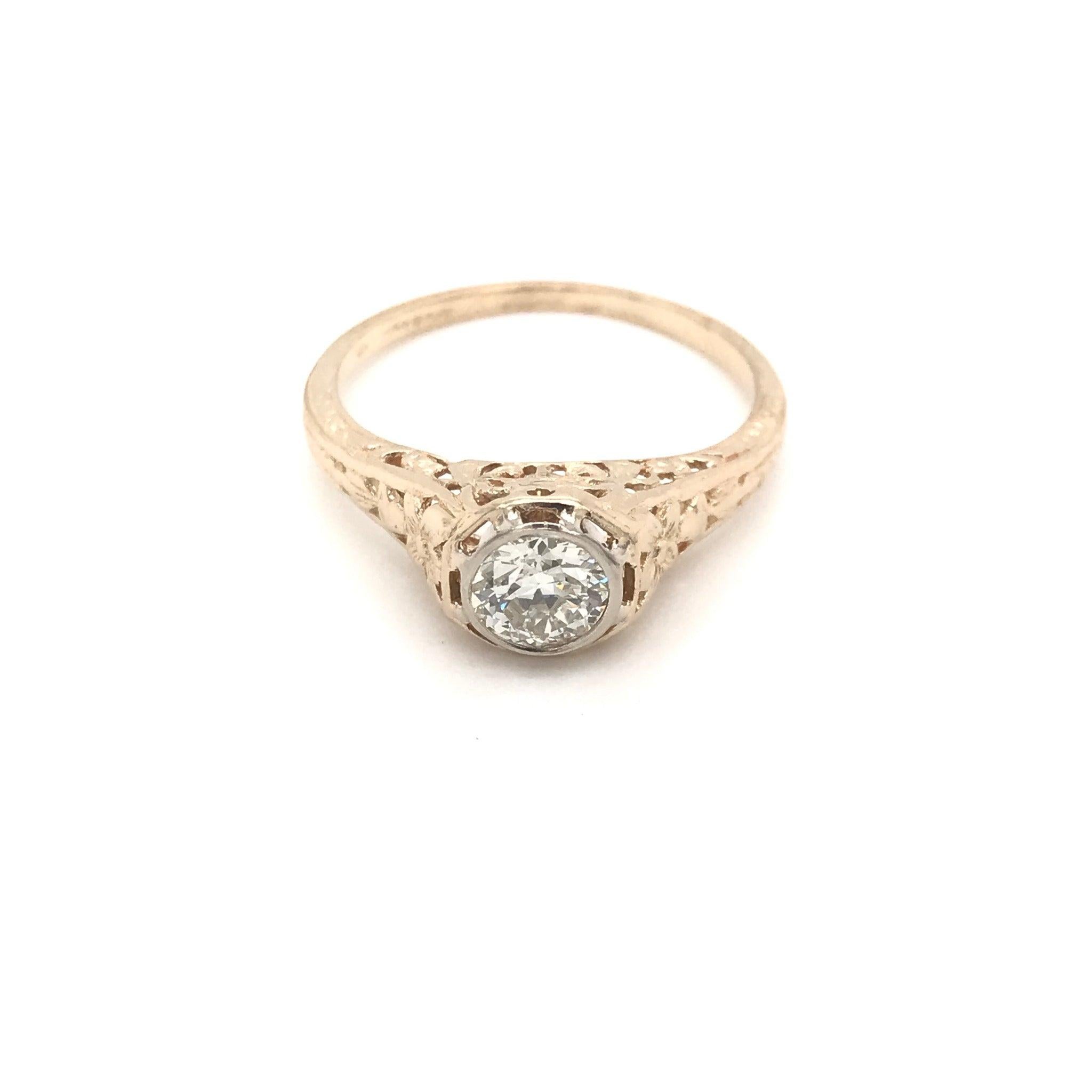 This antique piece was handcrafted during the early twentieth century. This sweet and simple solitaire style features a sparkling half carat ( 0.50 ) diamond in the center. The center diamond grades an I in color, VS1 in clarity. The center diamond