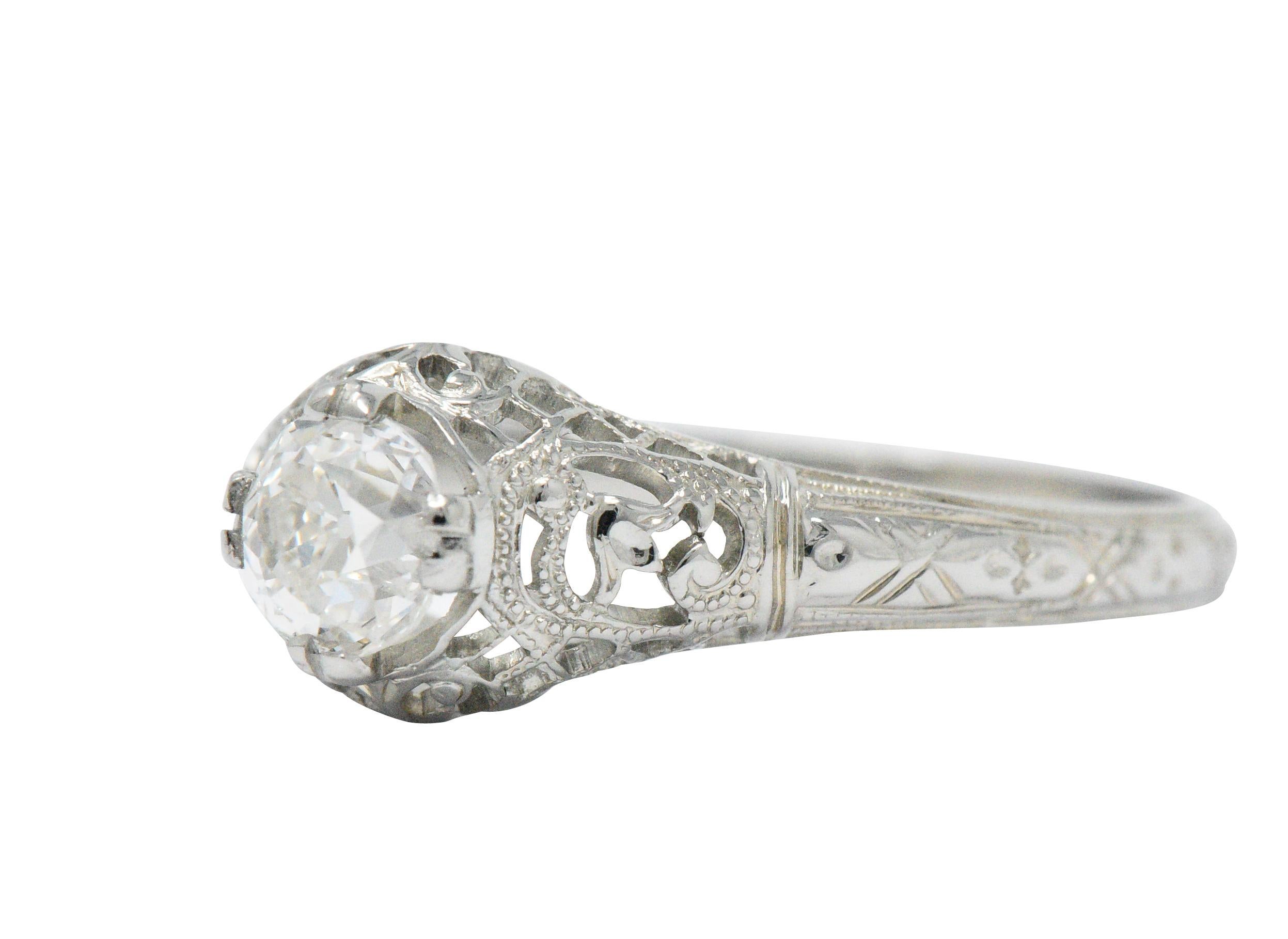 Centering an old mine cut diamond weighing 0.50 carat, H color with VS2 clarity

Prong set within mounting featuring a scrolled tulip motif at each cardinal point

With pierced lattice gallery with milgrain detail and engraved foliate shank

Tested