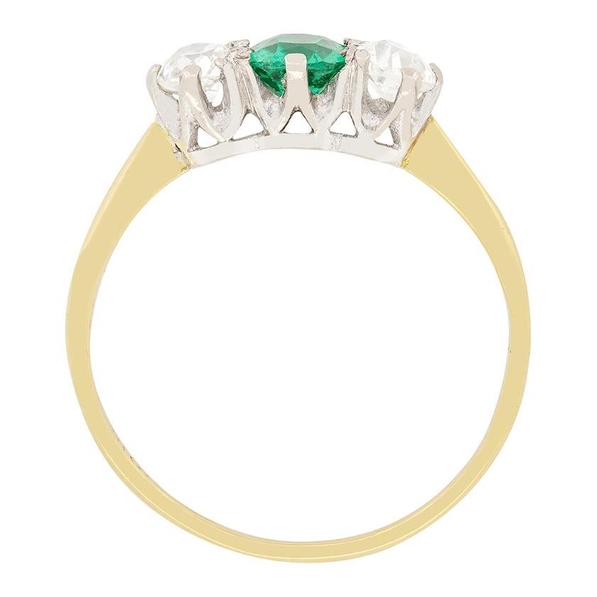 This beautiful Edwardian trilogy ring features a vibrant, 0.50 carat cushion emerald at it’s centre flanked by a pair of 0.35 carat old cut diamonds. All three stones are set into a platinum collet to highlight their true colour. The diamonds range