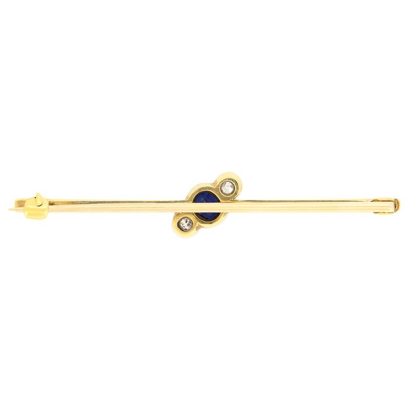 Diese charmante Brosche stammt aus der Edwardianischen Zeit. In der Mitte befindet sich ein einkarätiger Saphir im Kissenschliff, diagonal flankiert von einem Paar Diamanten im Altschliff. Der leuchtend blaue Saphir hat ein Gewicht von 0,50 Karat