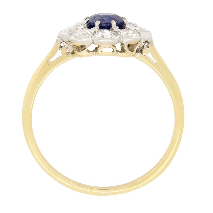 Dieser charmante Ring stammt aus der Edwardianischen Ära. In seinem Zentrum befindet sich ein lebendiger Saphir im Altschliff mit einem Gewicht von 0,50 Karat. Der Saphir ist in Krallen gefasst und von acht Diamanten im Altschliff mit einem Gewicht
