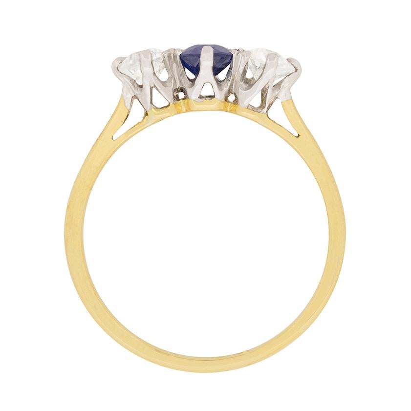 This beautiful Edwardian three stone ring features an oval cut sapphire between two diamonds. The sapphire is 0.50 carat, and has a vibrant blue colour. The diamonds are old cut, and are 0.25 carat each. They are G colour and VS1 clarity and add a