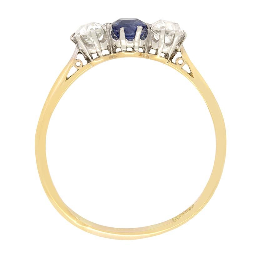 This wonderful trilogy ring dates back to the Edwardian period. At the heart of the ring lies an old cut sapphire weighing 0.50 carat, flanked on either side by two 0.30 carat old cut diamonds. The diamonds match in quality, with both being H in
