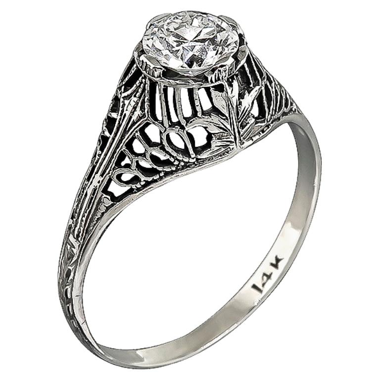 This elegant handmade 14k white gold engagement ring from the Edwardian era is centered with a sparkling round cut diamond that weighs 0.51ct. graded G with VS1 clarity. The ring is stamped 14K and weighs 1.4 gram.
It is currently size 6 3/4, and