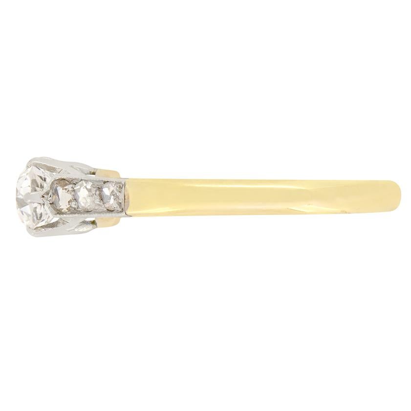 Cette bague solitaire intemporelle de style édouardien est ornée d'un diamant taille ancienne de 0,56 carat. D'une couleur G et d'une pureté VS2, ce magnifique diamant est serti en platine. Accentuant le diamant central, trois diamants taillés en