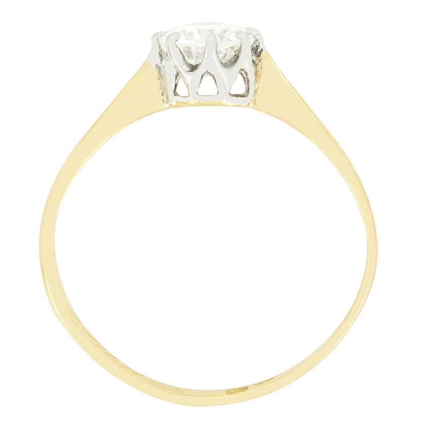 This classic solitaire ring dates to the Edwardian era. A single 0.58 carat old cut diamond takes centre stage. The diamond has a colour of H and clarity of SI1. It has been elegantly claw set into a platinum collet, with a contrasting band of 18