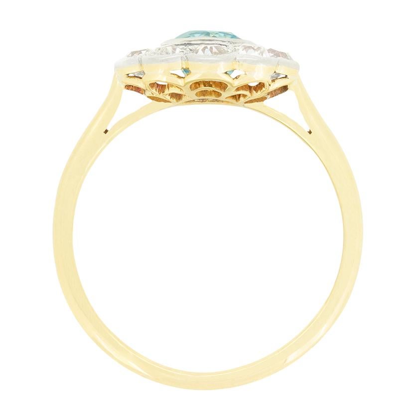 Risalente all'epoca edoardiana, questo anello a grappolo del 1910 presenta un'acquamarina centrale circondata da un gruppo di diamanti di vecchio taglio. Il taglio rotondo dell'acqua pesa 0,70 carati ed è incastonato a sfregamento. I diamanti