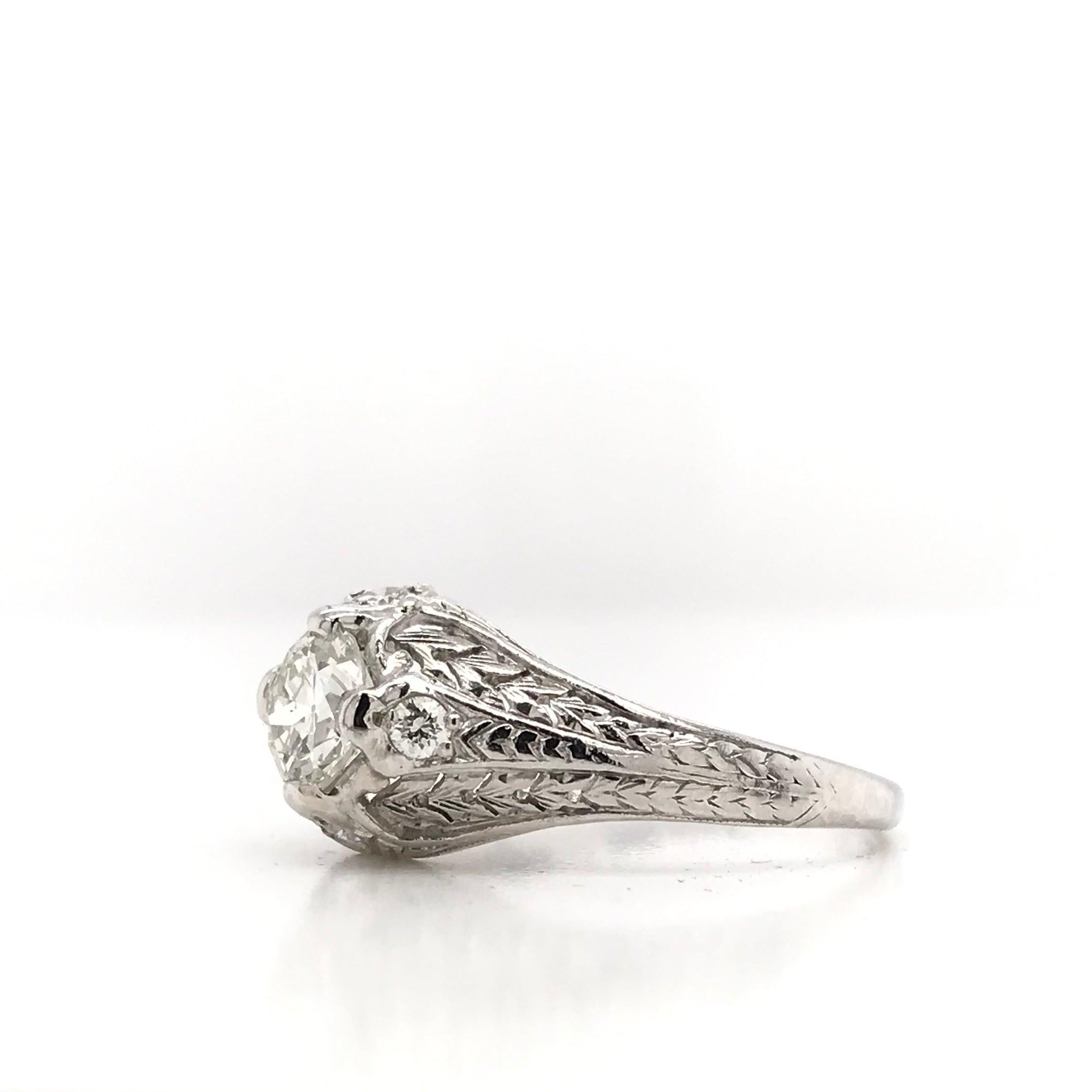 This antique piece was handcrafted sometime during the Edwardian design period ( 1901-1920 ). The setting is platinum and features many charming details. The center diamond measures approximately 0.71 carats and grades I in color, SI1 in clarity.