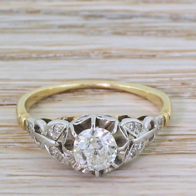 A magnificent Edwardian engagement ring. The old mine cut diamond in the centre is blindingly white, internally clean and absolutely fizzing with fire and brilliance. The centre stone is secured in an eight-claw buttercup settings, with wonderfully