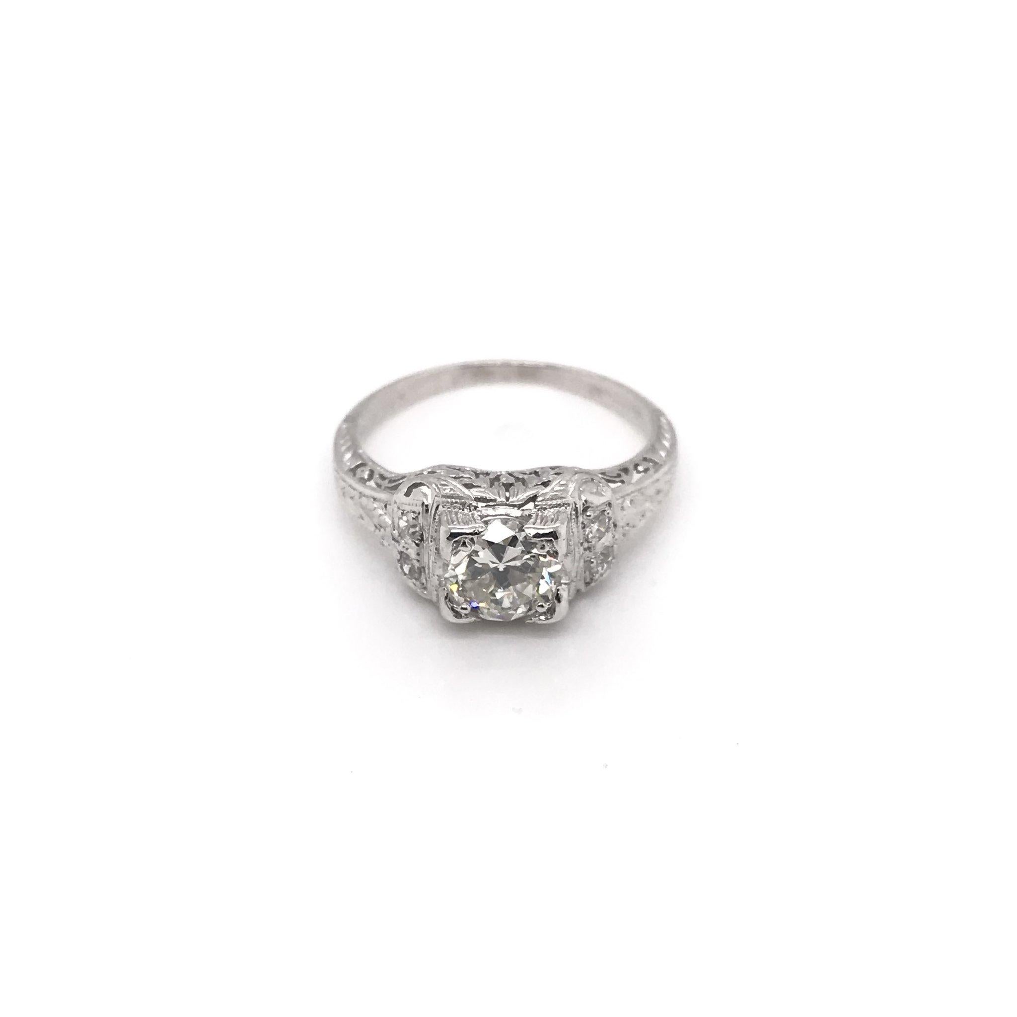 This antique piece was handcrafted sometime during the Edwardian design period ( 1900-1915 ). The platinum filigree setting features a gorgeous 0.74 carat center diamond that grades J in color, SI1 in clarity. The setting features enchanting floral