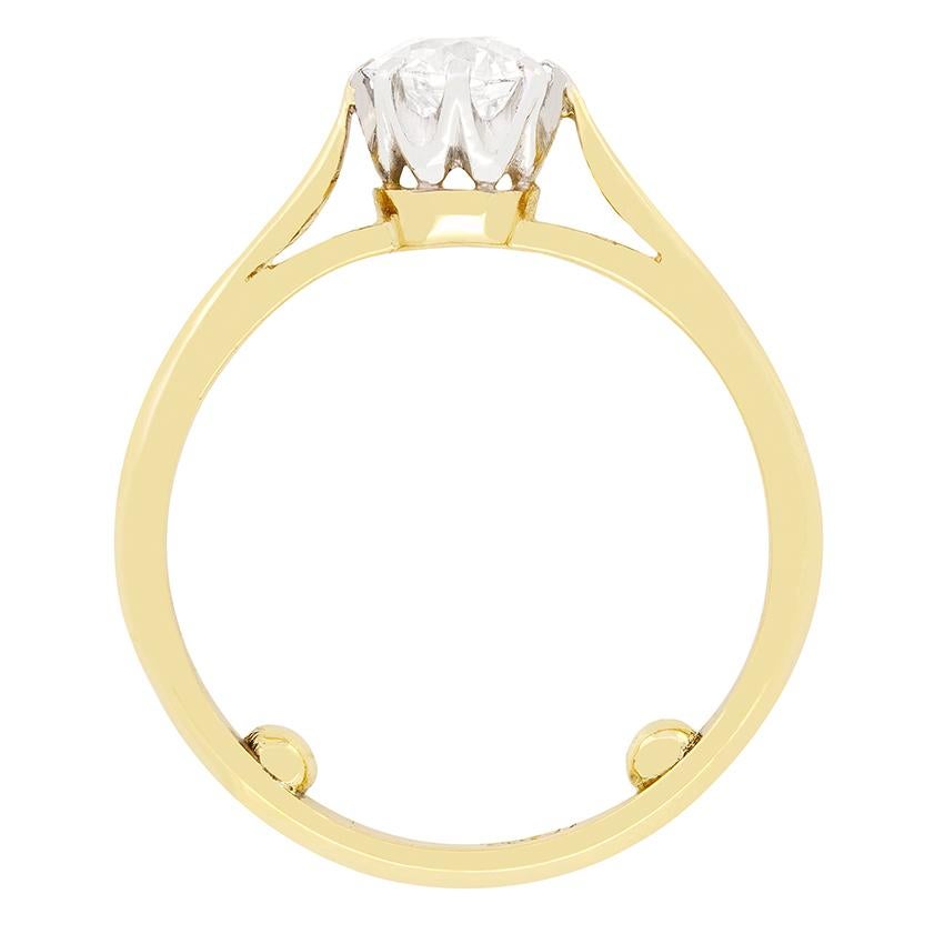 This timeless Edwardian solitaire engagement ring features a glistening 0.75 carat old cut diamond, finely claw set into a platinum collet. The diamond is G in colour and SI1 in clarity. A band of 18ct yellow gold band is elegantly joined to the