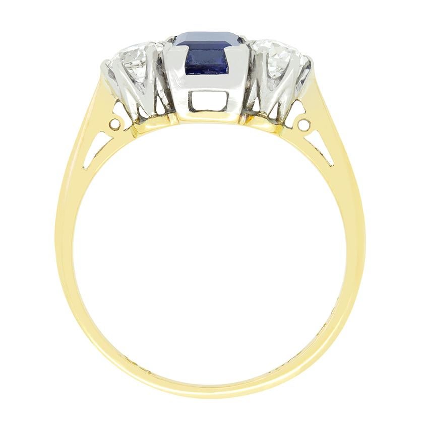 Realizzato nel 1910, questo splendido anello trilogy edoardiano presenta uno zaffiro blu intenso affiancato da diamanti. Al centro, lo zaffiro da 0,75 carati con taglio a baguette è incastonato ad angolo nel platino. Ognuno degli scintillanti