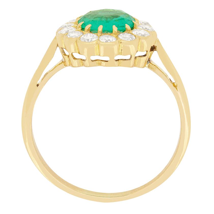 A beautiful natural emerald takes centre stage in this Edwardian cluster ring. The vivid green emerald weighs 0.80 carat and is an old cut stone. Claw set into 18 carat yellow gold the emerald is encircled by a cluster of thirteen old cut diamonds.