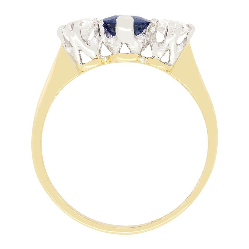 Datant de la période édouardienne, cette superbe bague à trois pierres présente un saphir bleu vif en son centre, flanqué d'une paire de diamants étincelants de taille ancienne. Le saphir de la vitrine est une pierre ancienne de 0,80 carat, les deux