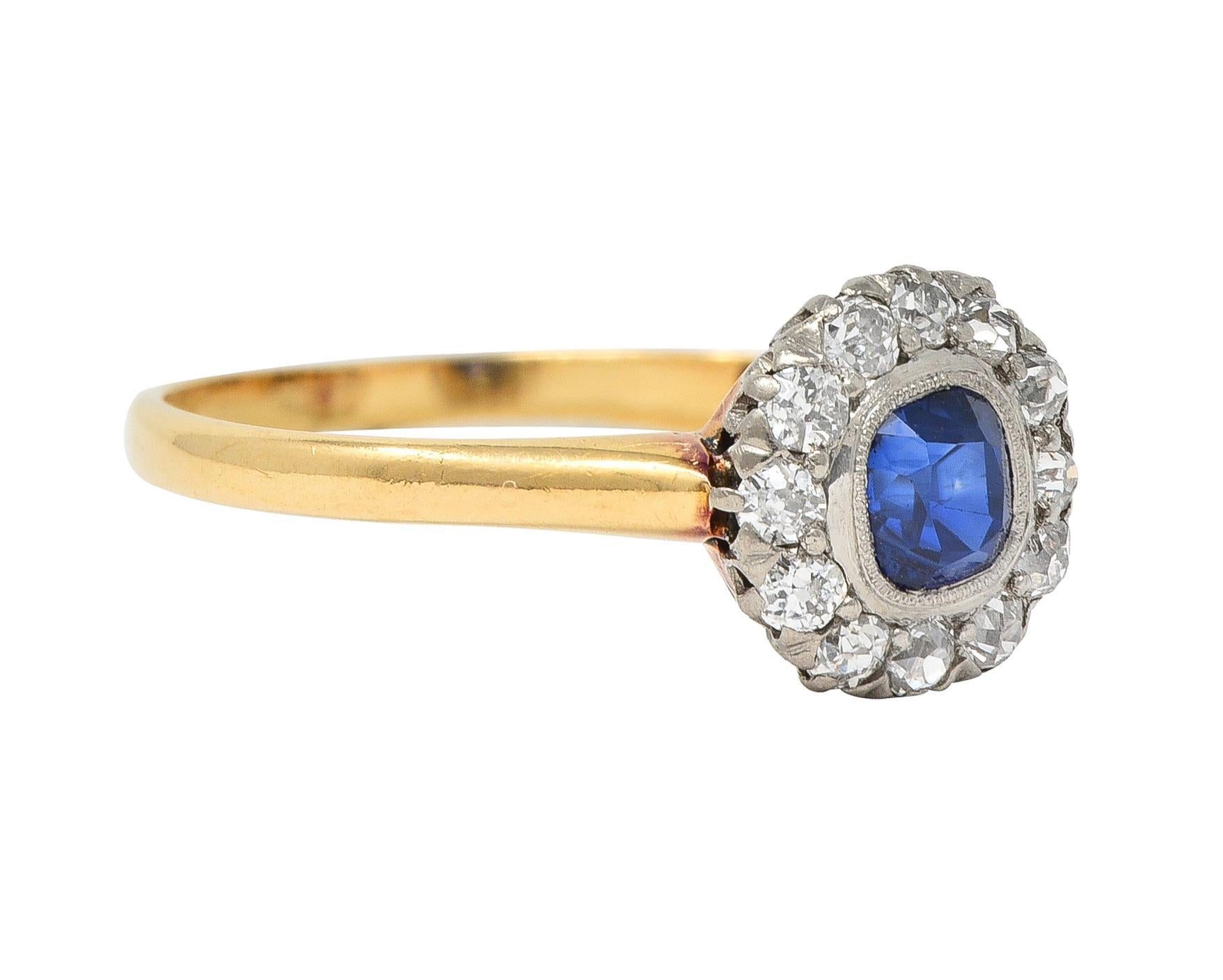 Centering a cushion cut sapphire weighing approximately 0.53 carat - transparent medium blue 
Set in a platinum bezel with milgrain detail and halo surround 
Comprised of prong set old European cut diamond
Weighing approximately 0.30 carat total -