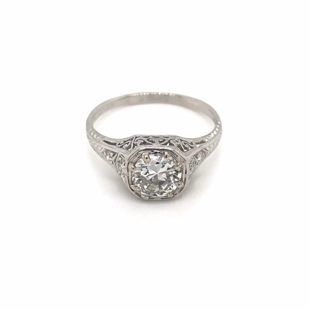 This beautiful antique piece was handcrafted in the early twentieth century. This Edwardian ring features a gorgeous 0.90 carat diamond in the center. The center diamond grades approximately an I in color and VS2 in clarity. The setting is platinum