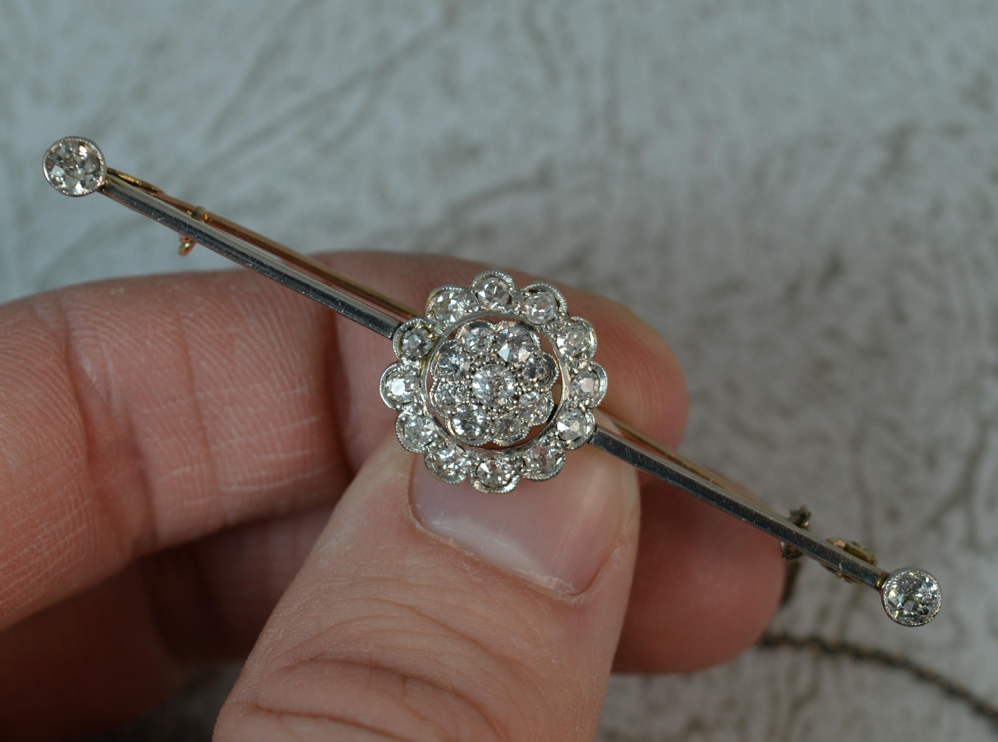A beautiful Victorian period brooch.
Solid 18 carat yellow gold example with platinum front to bar and settings.
Designed with a three tier flower cluster set with old cut diamonds in grain bezel settings. Complete with a single bar to each side and