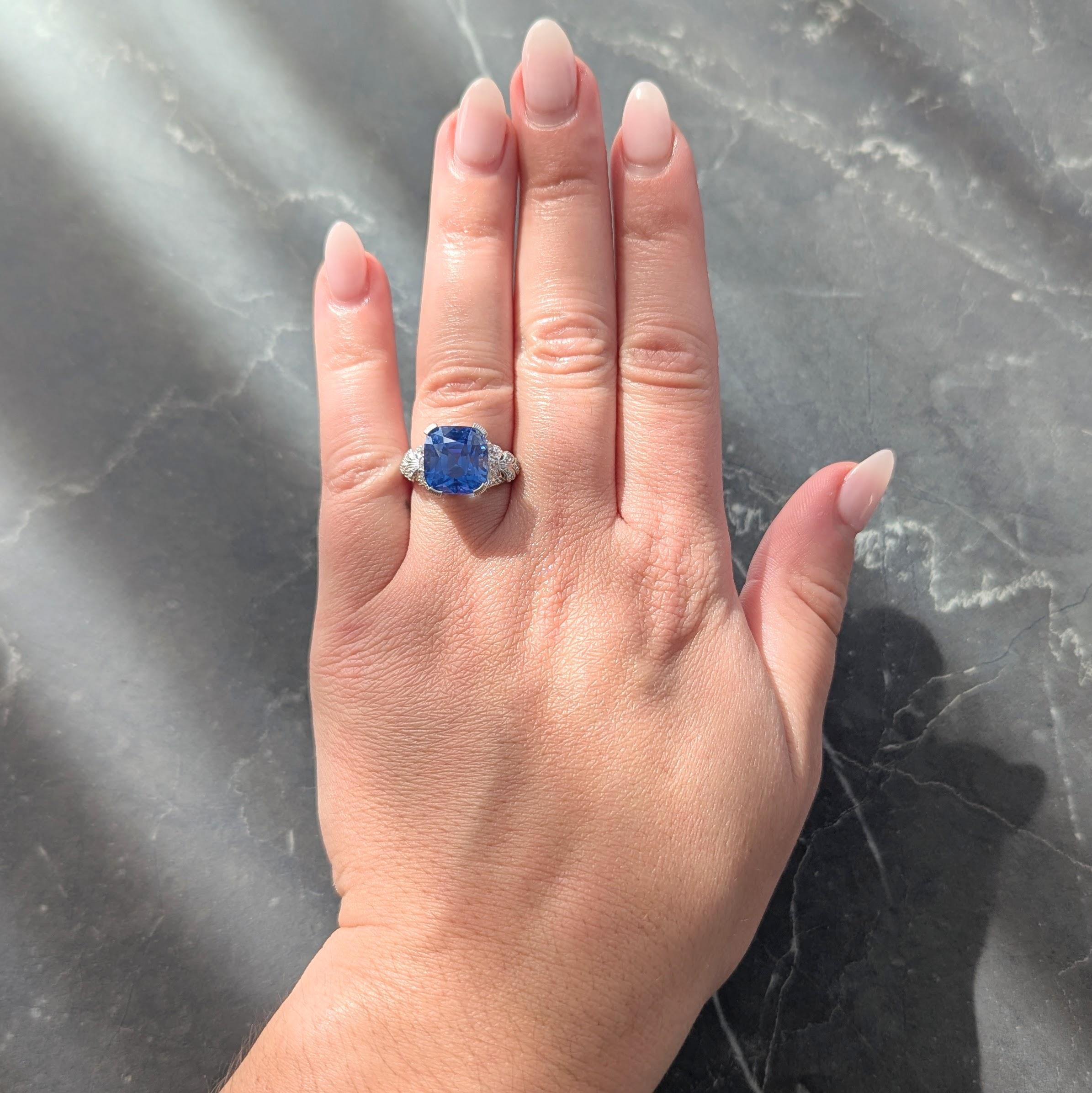 En el centro un zafiro talla cojín de 9,32 quilates - azul medio vivo transparente
De origen natural de Ceilán (Sri Lanka) y sin indicios de tratamiento térmico
Engastado con puntas grabadas con motivo de azahar en una galería calada