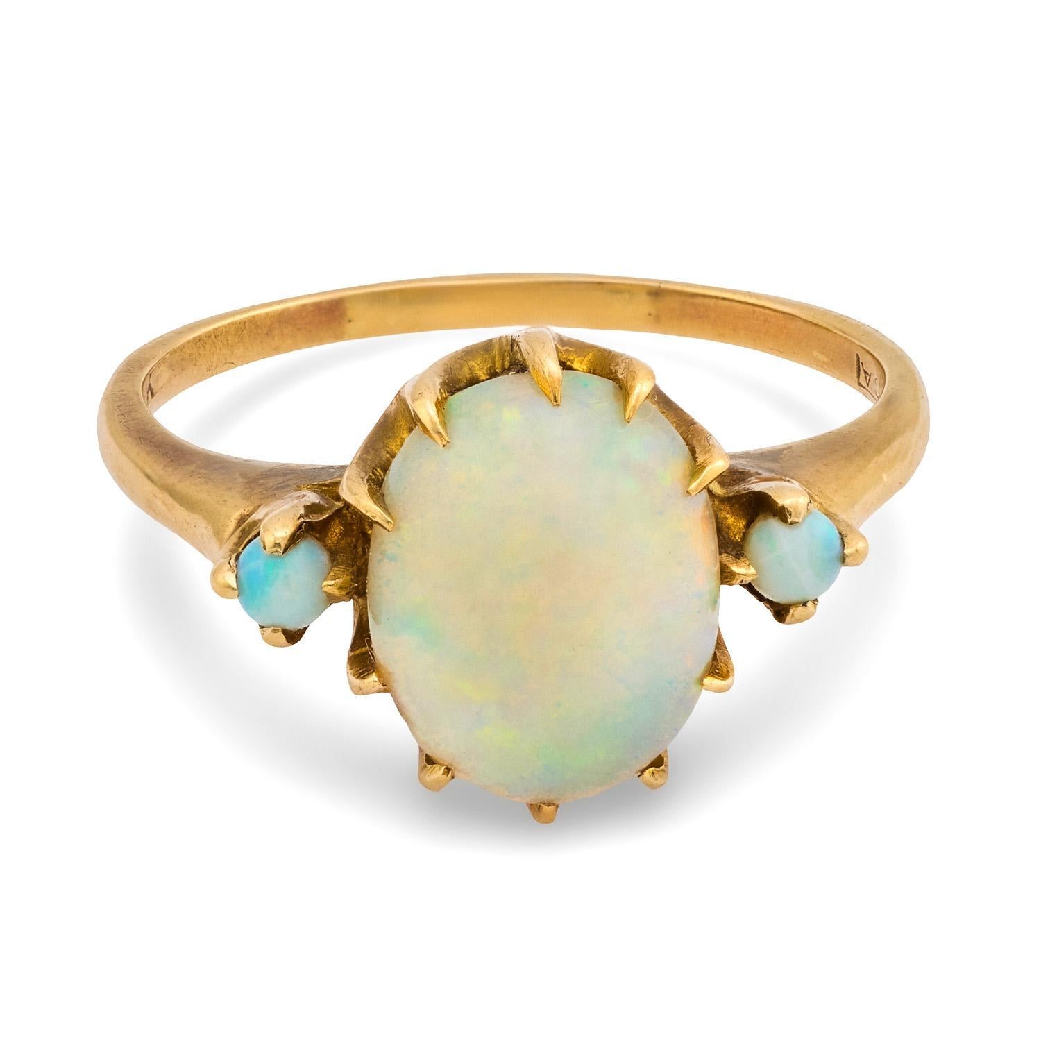 Uno splendido anello di opale dell'epoca edoardiana (ca. 1910)! Questo delizioso pezzo è realizzato in oro giallo 10k e presenta 3 cabochon di opale disposti orizzontalmente. L'opale centrale, di forma ovale, è molto più grande delle altre due