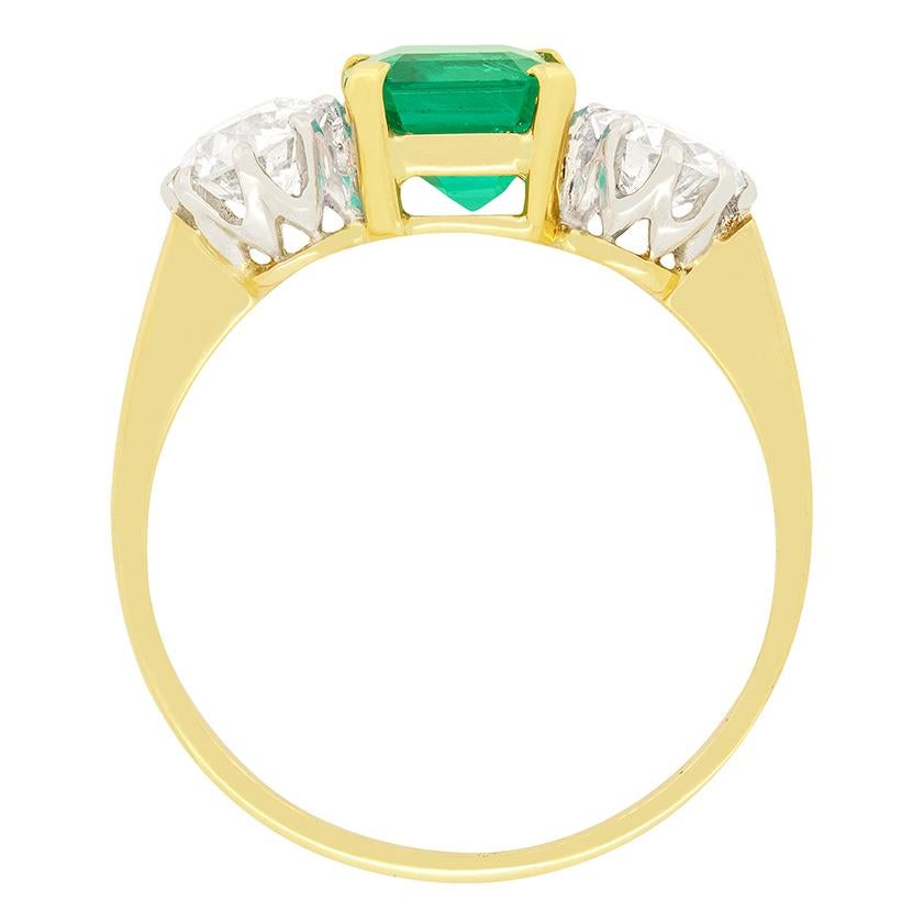 This marvellous Edwardian ring features a trio of stones with a fabulous 1.14 carat natural Columbian emerald taking centre stage. Proudly sitting beside the green emerald are two 0.50 carat old cut diamonds creating an eye-pleasing contrast. The