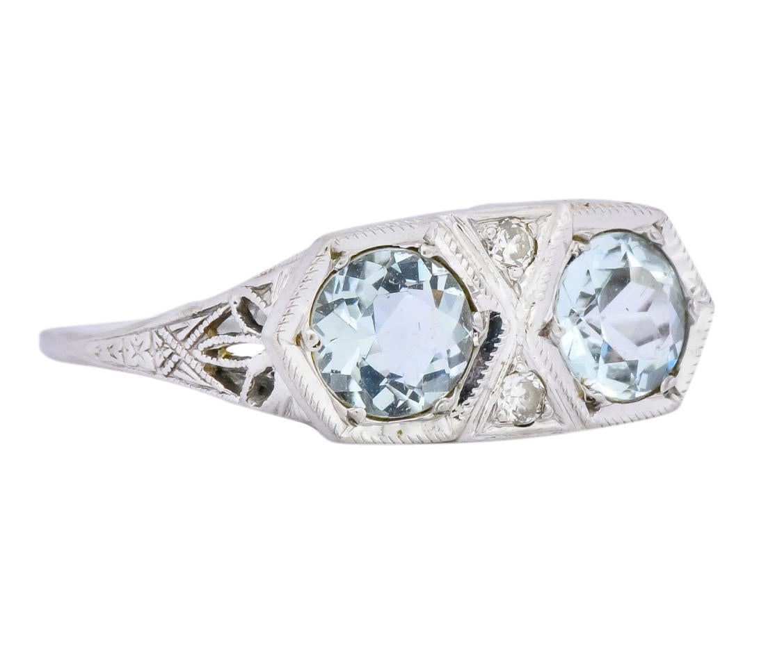 Centering two transitional diamonds, set in triangle motif, weighing approximately 0.06 carat total, eye-clean and white

Flanked by a pair of round cut aquamarines weighing approximately 1.24 carat total, transparent light blue in color

1.30