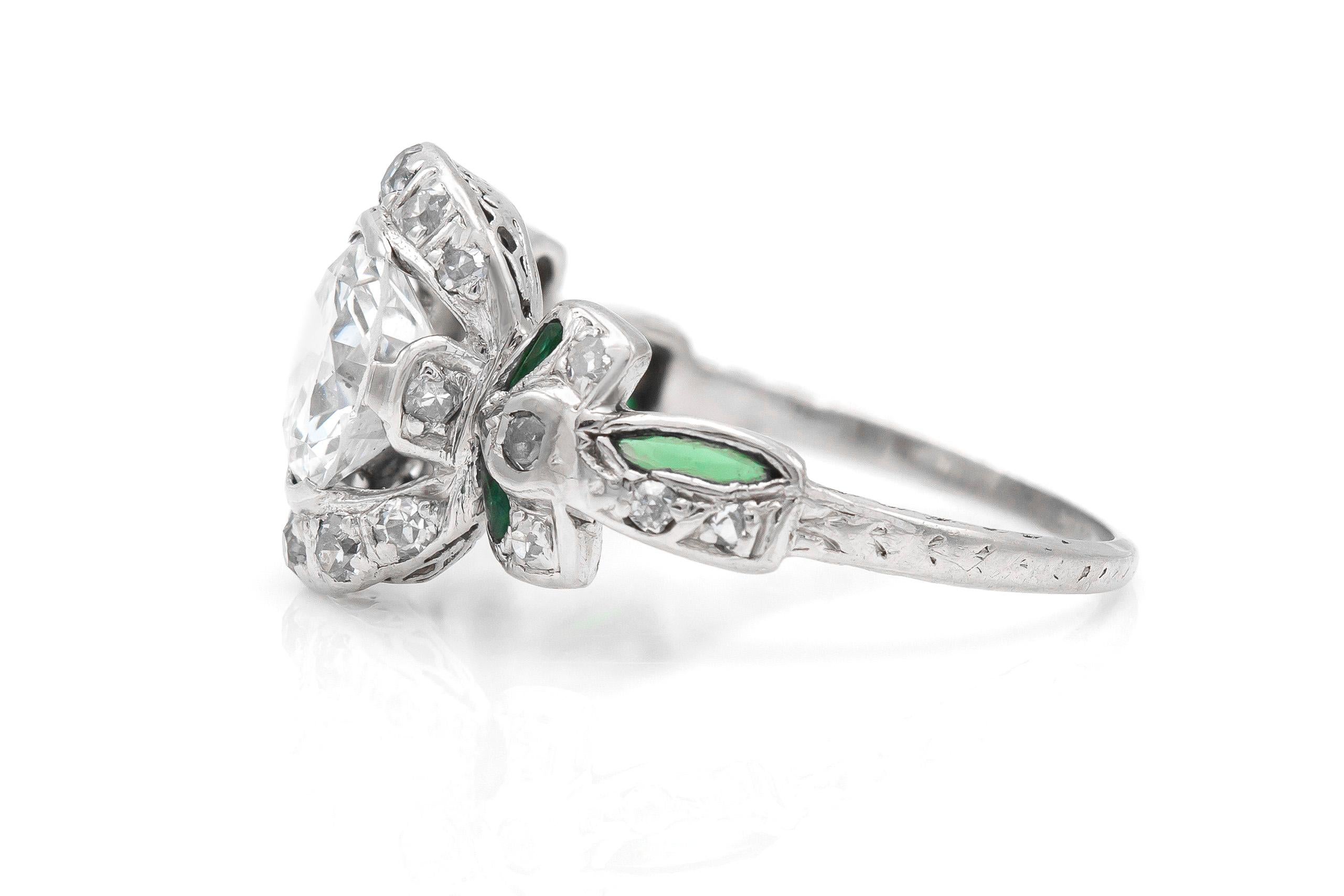 Finely crafted in platinum with an Old European cut center diamond weighing approximately 1.30 carats.
Color G-H       Clarity SI1
The ring features diamonds and emeralds in the setting.
Edwardian, circa 1910s