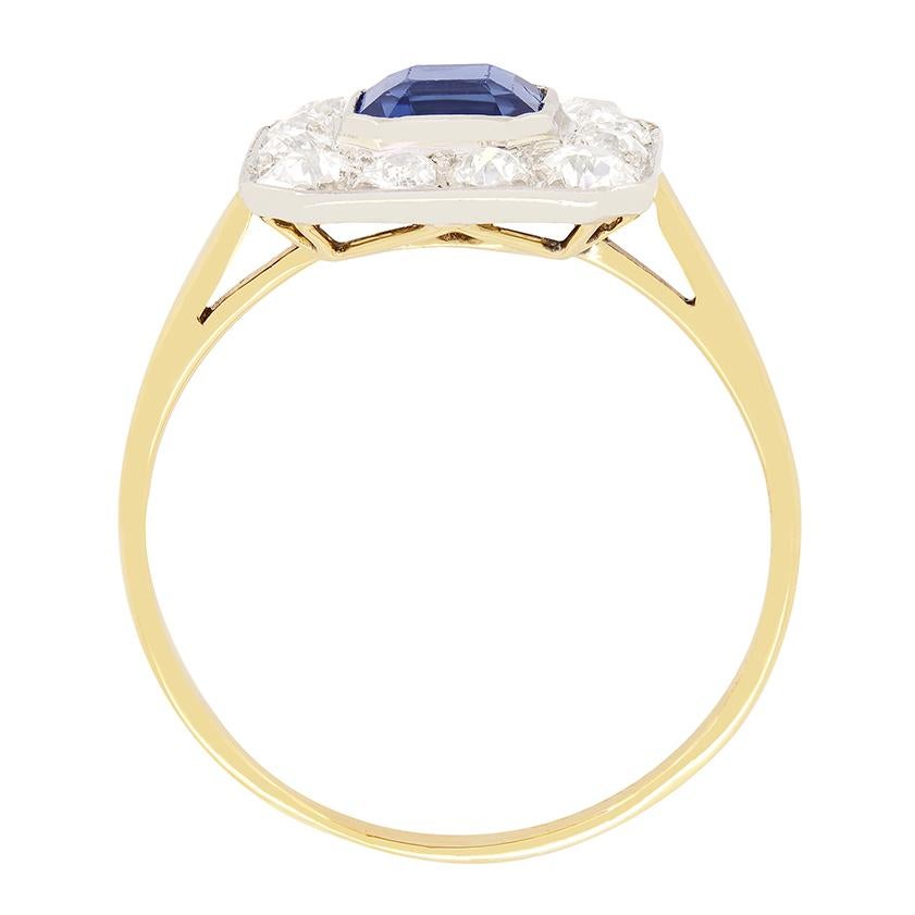 An enchanting deep blue, natural sapphire sits central to this cluster ring from the Edwardian era. The asscher cut sapphire weighs 1.30 carat and is rub over set into platinum. A total of 0.80 carat in old cut diamonds surrounds the central stone