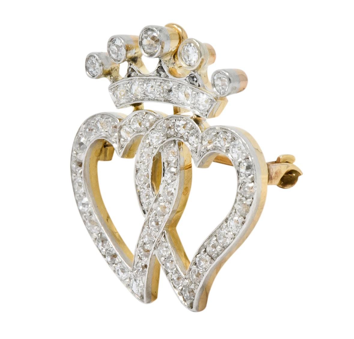 Designed as two crowned open hearts, intertwined

Set throughout with old European cut diamonds weighing approximately 1.35 carats total, H to J color and VS clarity

Completed by sliding hidden bale and pin stem with locking closure

Tested as
