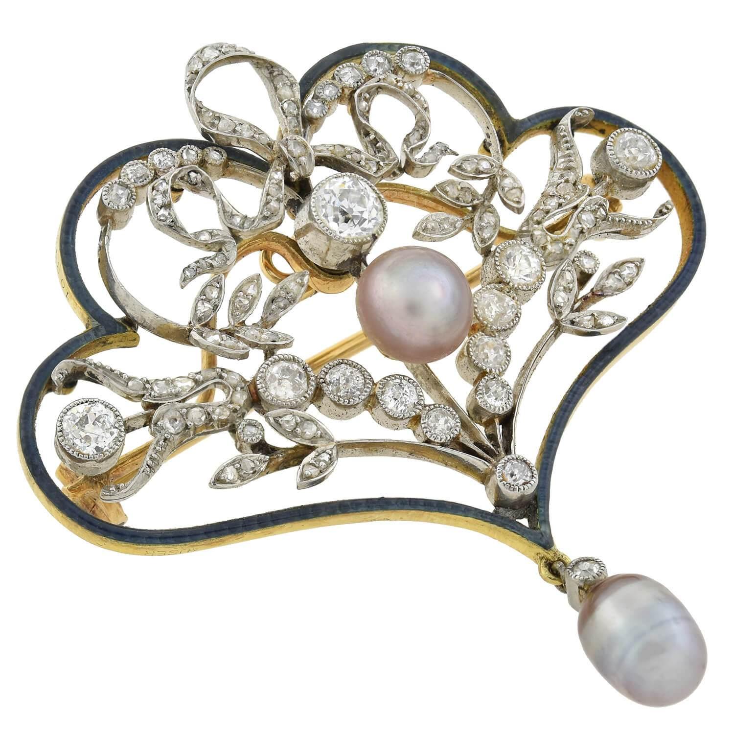 An exquisite diamond pin from the Edwardian (ca1910s) era! Crafted in 18kt yellow gold and platinum, this substantial piece displays a gorgeous foliate and ribbon design accented by sparkling diamonds, lustrous pearls and soft enameling. Old Rose