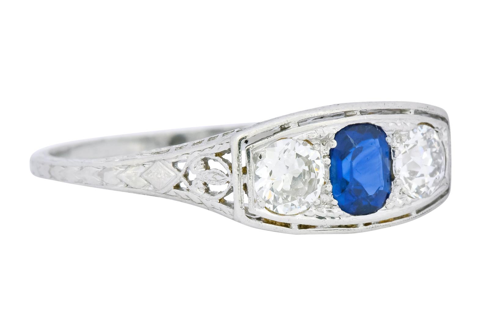 Centering an oval cut sapphire weighing approximately 0.60 carat, transparent and a brilliant royal blue color

Flanked by two old European cut diamonds weighing approximately 0.78 carat total, H/I color and VS clarity

Bead set, East to West, in a