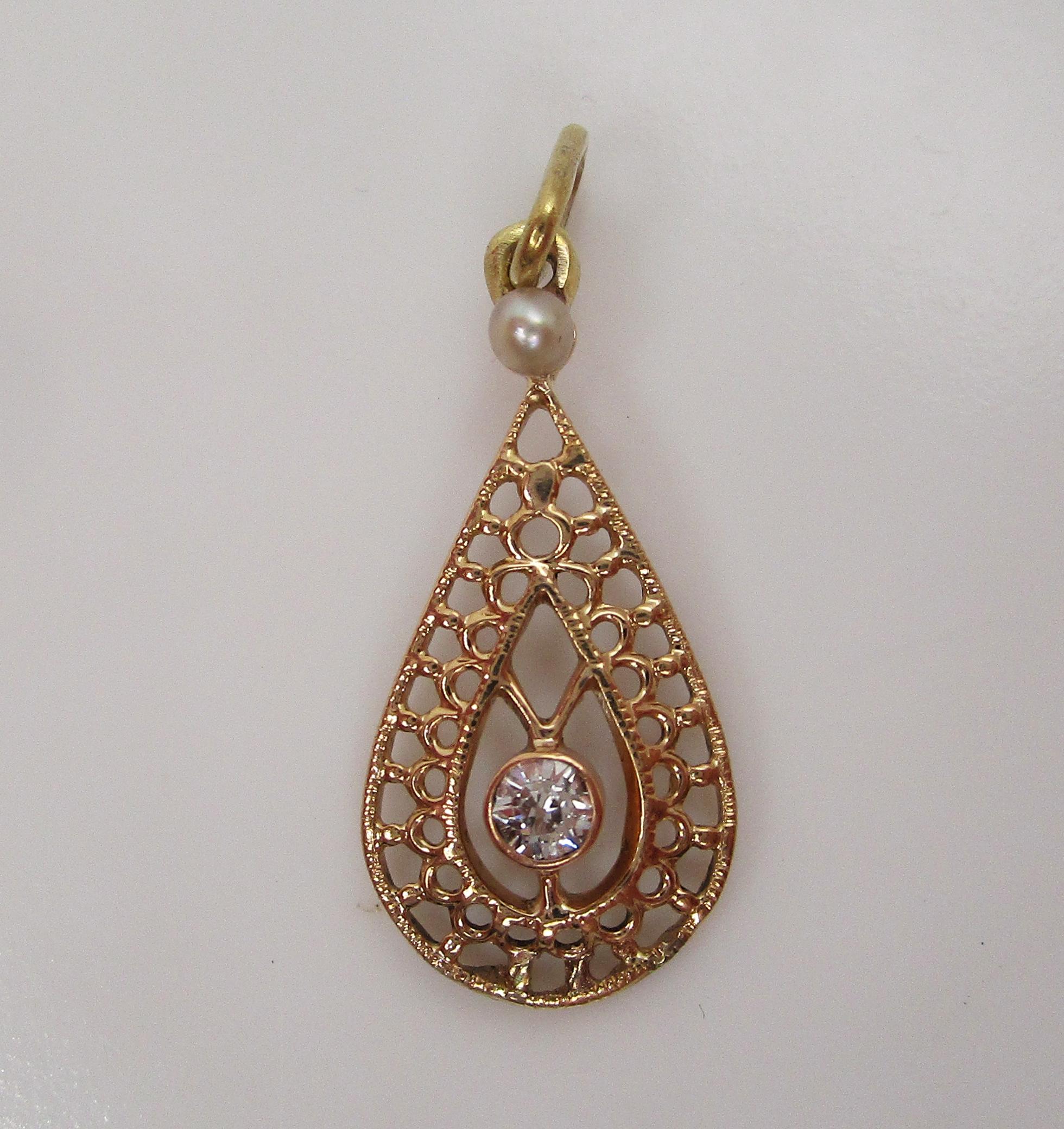 This lovely Edwardian pendant is in 14k yellow gold and features both a seed pearl and delicate diamond accent in an open pear design! The open design of the pendant creates a lacy look that is delicate and beautiful! At the top of the pendant sits