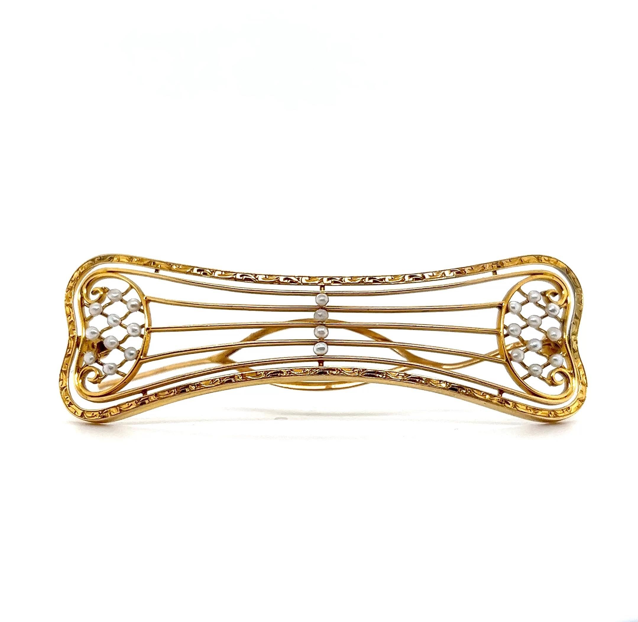 Délicat exemple de l'élégance édouardienne, cette barrette en or jaune 14 carats mesure 2,75 x 1 pouce et est ornée de vingt-quatre perles de rocaille lustrées de 3 mm, chacune soigneusement sertie pour créer un design raffiné et féminin. La