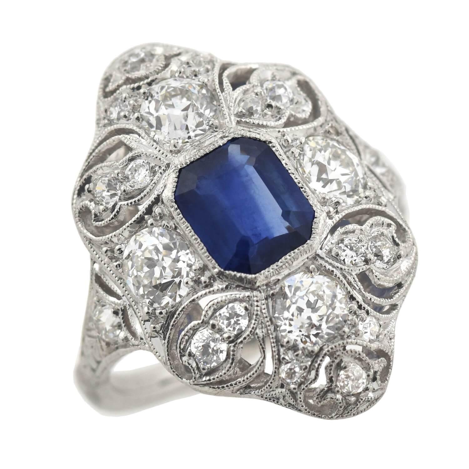 A stunning diamond and sapphire ring from the Edwardian (ca1915) era! This wonderful platinum piece has an elegant filigree setting with an elongated centerpiece that beautifully curves around the finger. Resting at the center is a stunning
