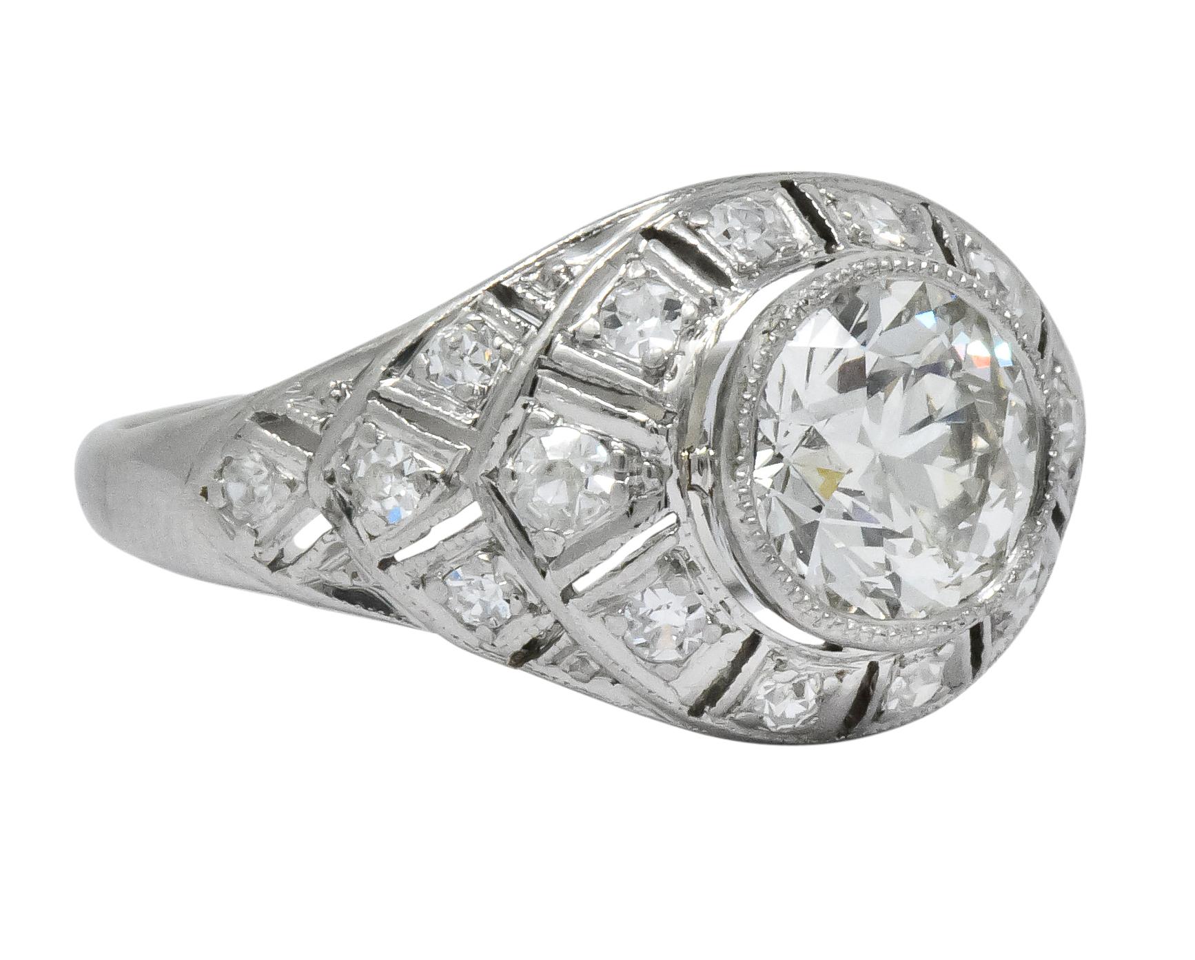 Millegrain bezel setting centering a round brilliant cut diamond weighing 1.14 carats, K color and VVS1 clarity

Surrounded by a pierced and tiered geometric motif, prong set with Swiss cut diamonds weighing approximately 0.26 carat total, H/I color