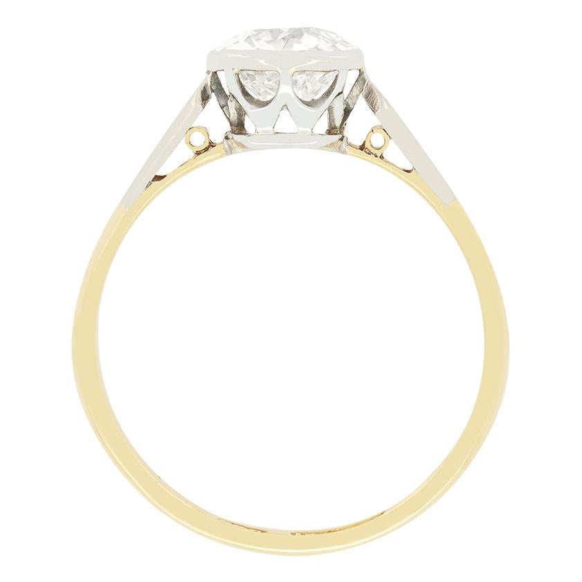 This stunning diamond solitaire ring dates to the Edwardian period. Rub over set into platinum the old cut diamond is an impressive 1.40 carat in size With a colour of H and clarity of VS2. The platinum collet sits between shoulders of the same