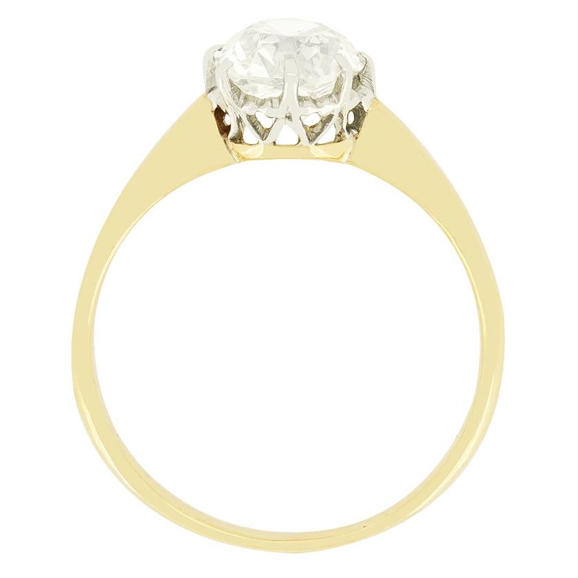 This elegant solitaire ring dates to the Edwardian era. A stunning 1.40 carat old cushion cut diamond takes centre stage, claw set within a platinum collet. The diamond is of I colour and SI1 in clarity. A simple band of 18 carat yellow gold
