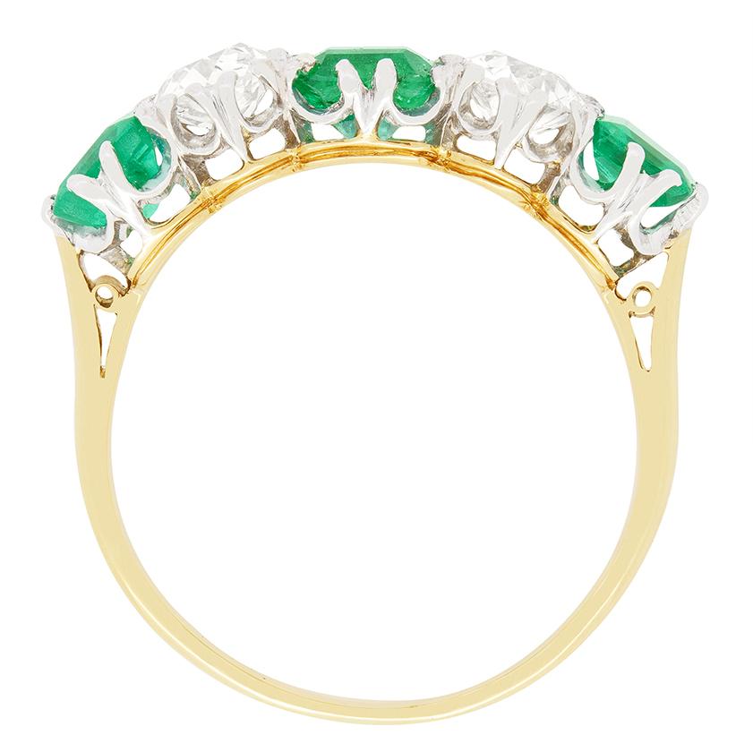 Ein Trio leuchtend grüner Smaragde wird in diesem schönen edwardianischen Schmuckstück von einem Paar Diamanten im Altschliff gekreuzt. In der Mitte sitzt der größte der drei Smaragde mit einem Gewicht von 0,60 Karat und an den beiden Enden befinden