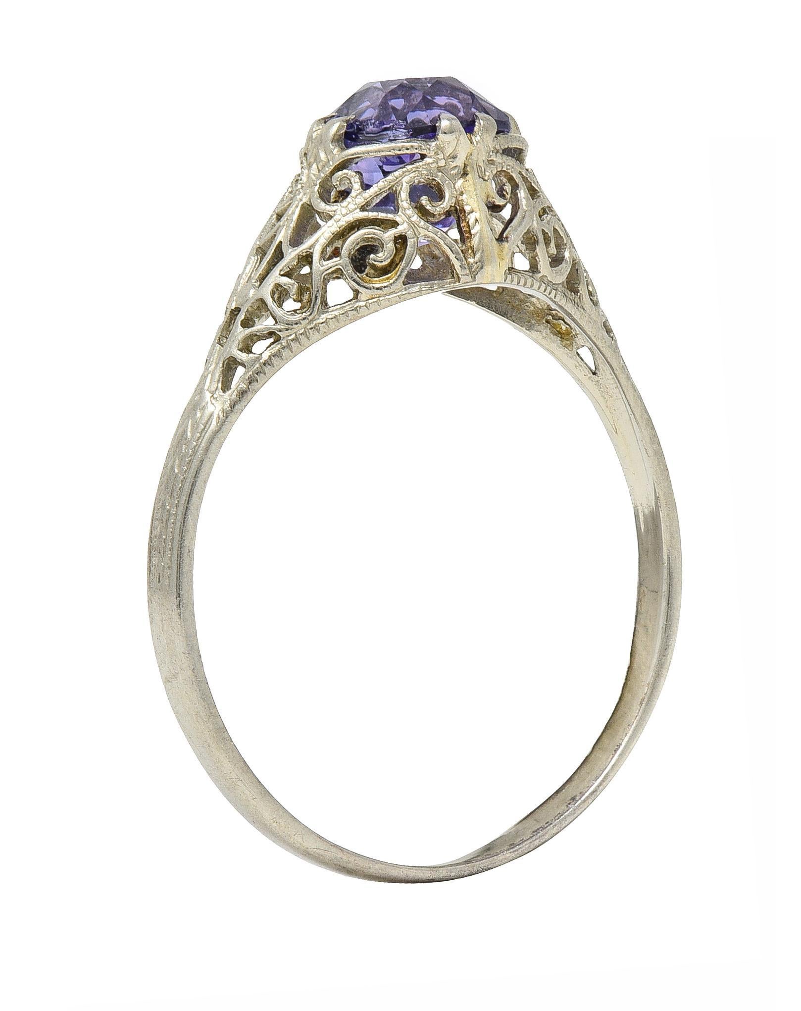Centering a cushion cut sapphire weighing 1.48 carats - transparent medium purple in color 
Natural Sri Lankan in origin with no indications of heat treatment 
Set with split-talon prongs with a pierced miligrain gallery
Featuring scroll and heart