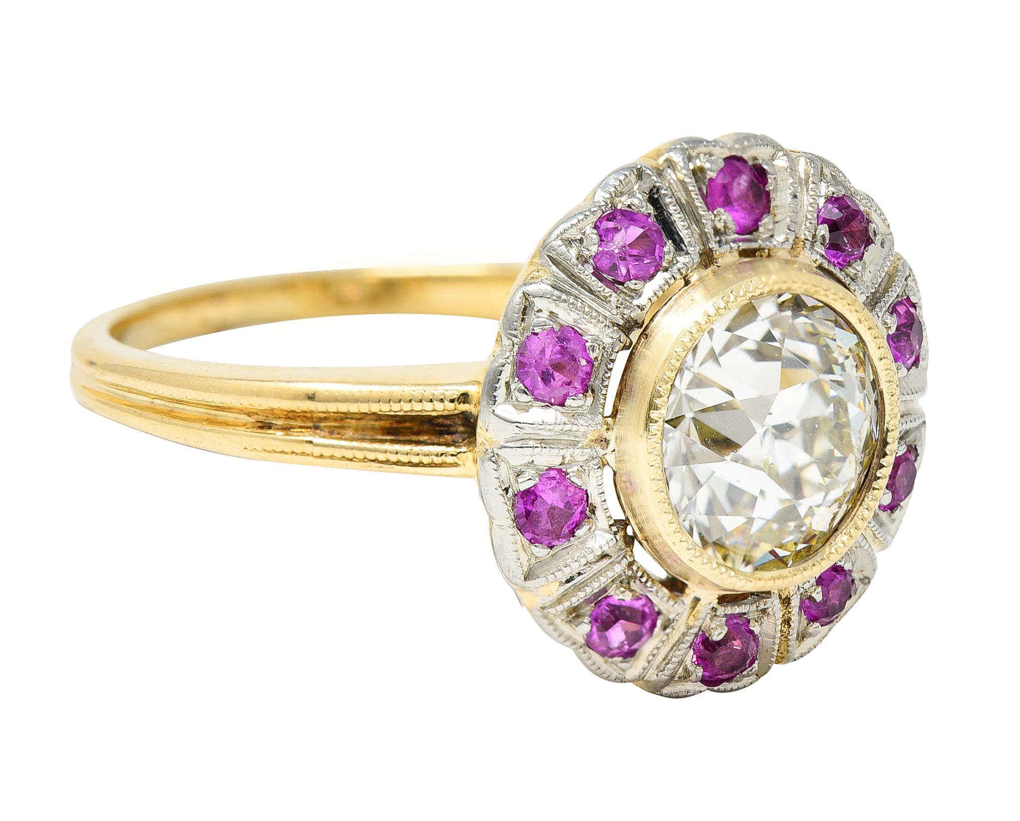 Centering an old European cut diamond weighing 1.14 carats total - M color with VS1 clarity. Set in a raised gold bezel with a platinum-topped surround featuring a halo of round cut rubies. Bead set and weighing approximately 0.35 carat total -